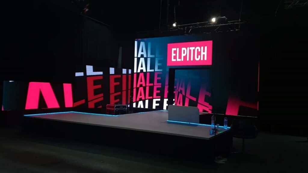 The built El Pitch stage, LED walls running the Finale title graphics in pink and blue with the ELPITCH mark above the doorway