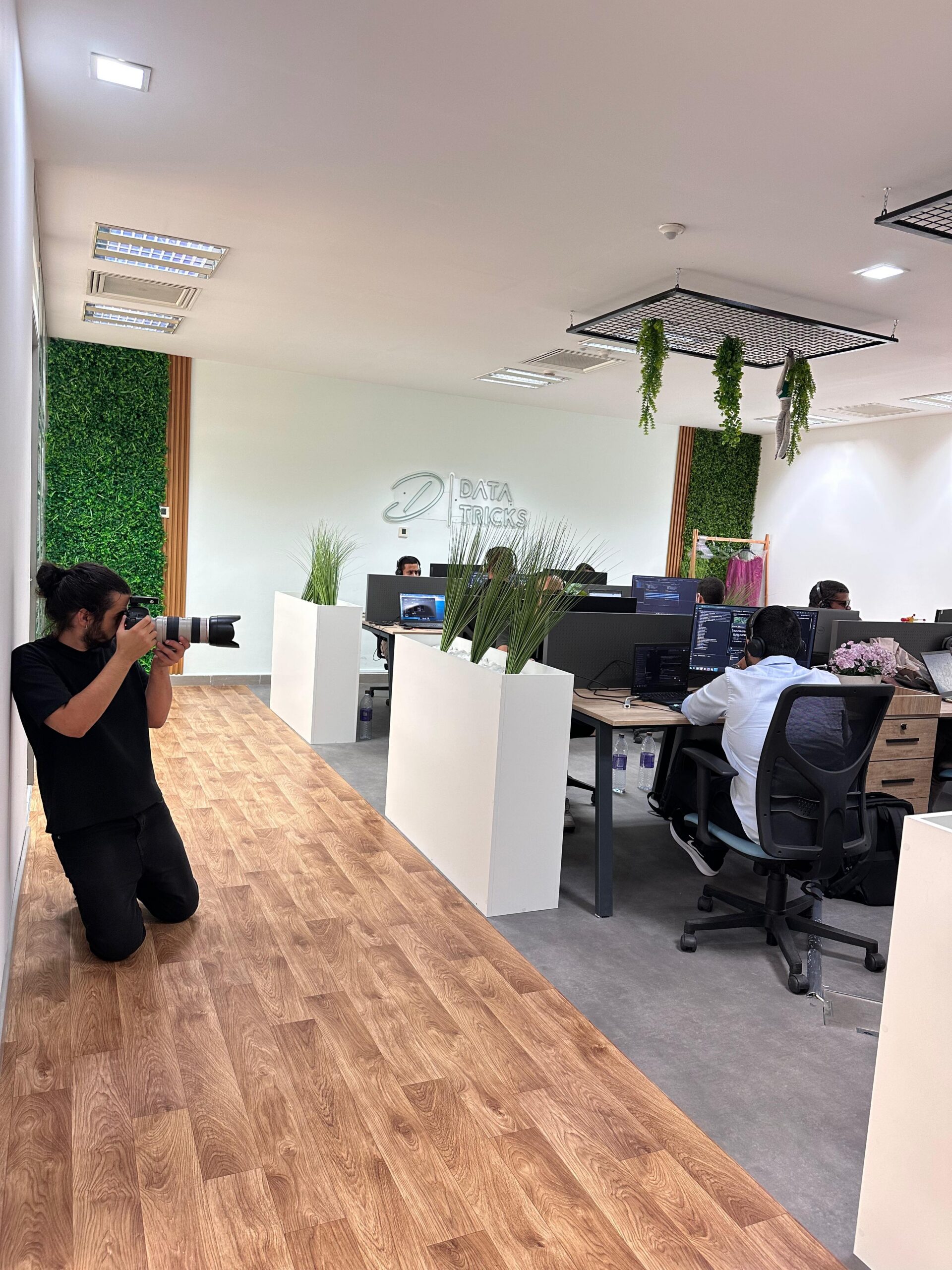 Behind the scenes: the photographer kneeling with a telephoto lens in the Data Tricks office